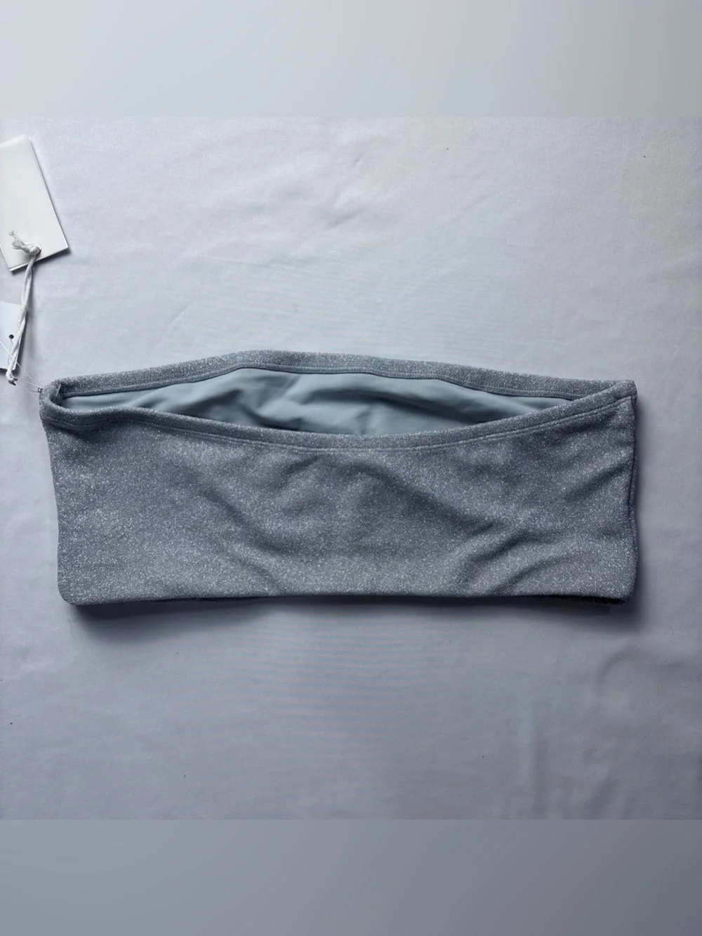 This Good American bandeau top features a shimmering silver fabric